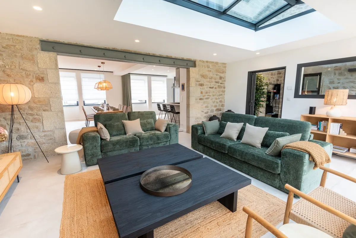 Sitzecke mit Samtsofas, offen zum Esszimmer und zum Wintergarten