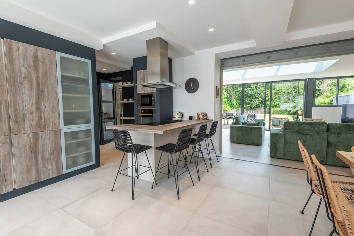 Moderne offene Küche mit Holztheke und Barhockern
