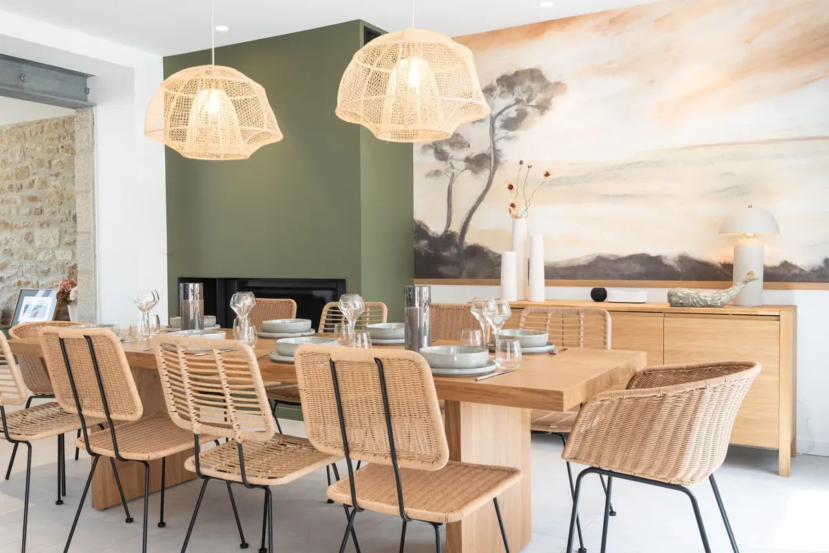 Esszimmer mit Eichentisch, Rattanstühlen, Rattan-Hängeleuchten und Panoramatapete