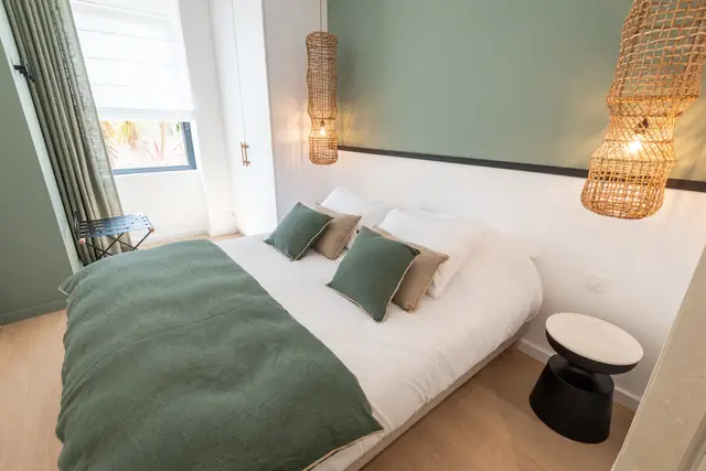 Queen-Bett im Zimmer Locqueltas und Rattanleuchte