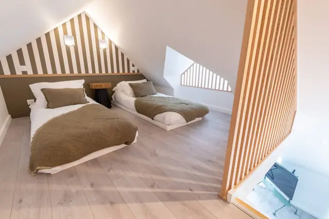 Mezzanine unter der Dachschräge mit zwei 90-cm-Betten und Raumteiler aus Holz