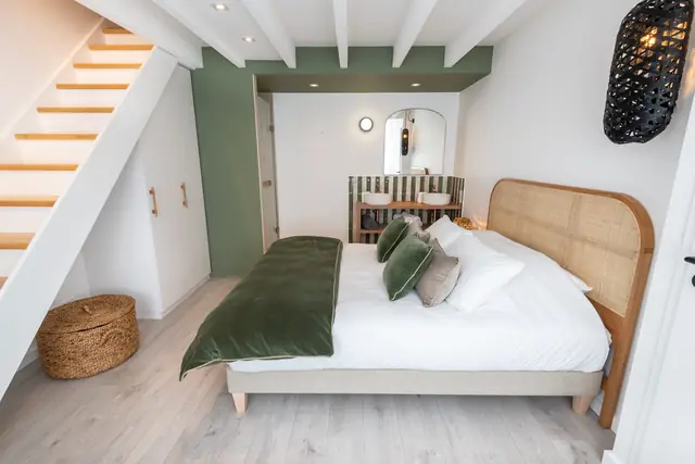 Queen-Bett mit Kopfteil aus Rattan und Treppe zur Mezzanine