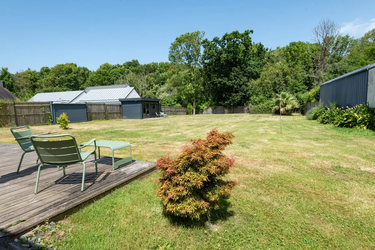 Großer eingezäunter Garten mit Spielhaus und Liegestühlen